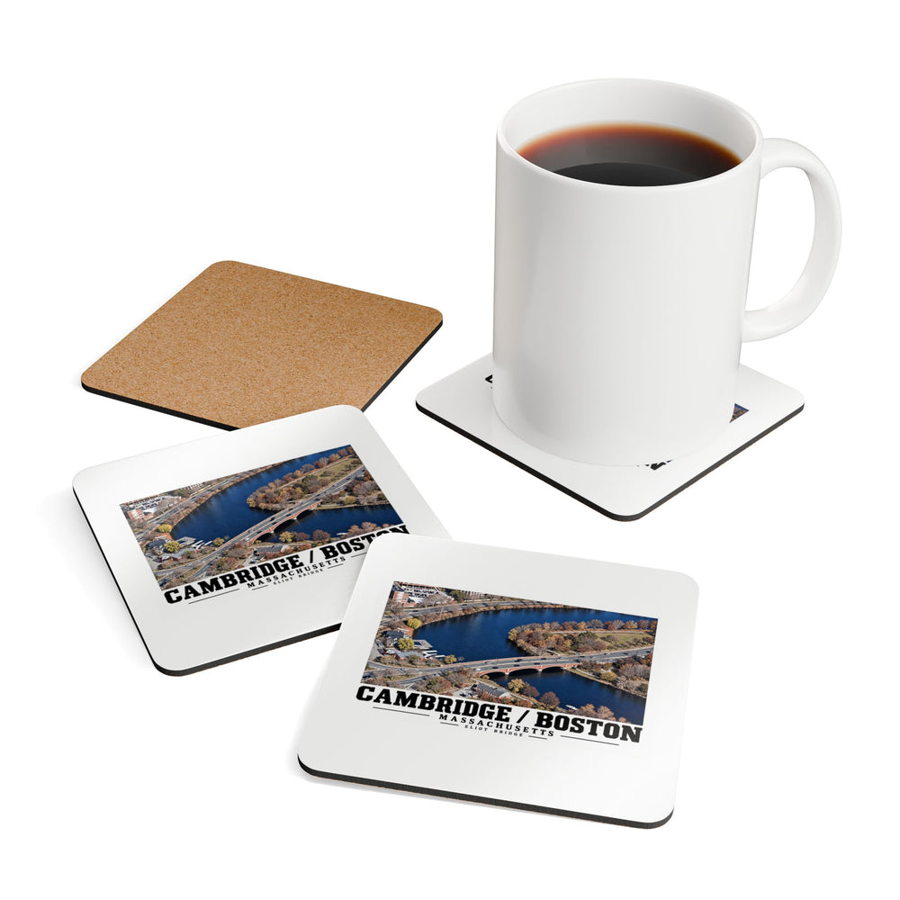 Coasters showing Eliot Bridge aerial river view artwork beside a plain white mug of coffee and a coaster's cork reverse