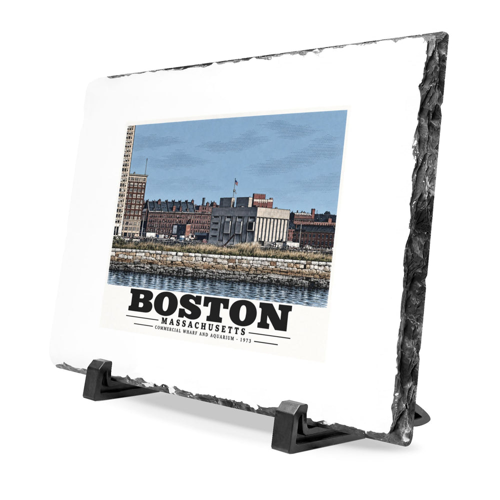 Angled rough-edged slate display on black stands showing Commercial Wharf and Aquarium waterfront buildings, stone seawall and harbor water artwork