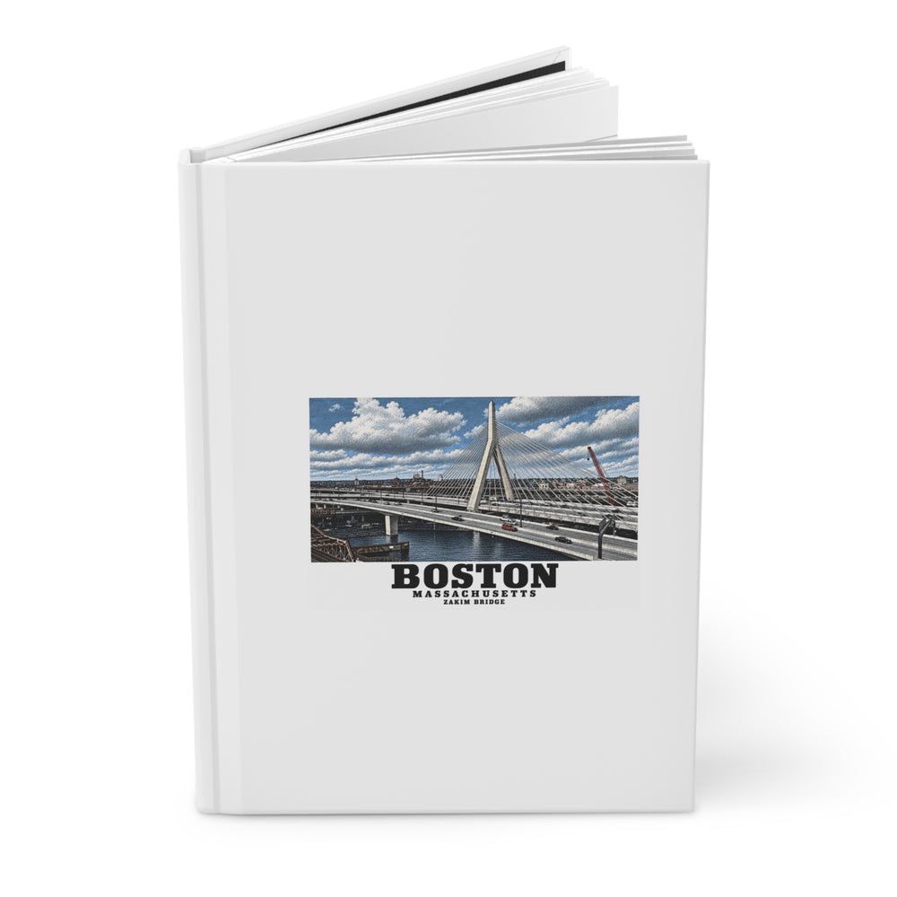 Partly opened white hardcover journal showing Zakim Bunker Hill Bridge cable-stayed towers and Charles River artwork on the front