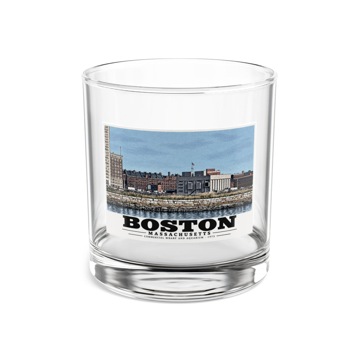Clear rocks glass showing Commercial Wharf and Aquarium waterfront buildings, stone seawall and harbor water artwork and Boston lettering