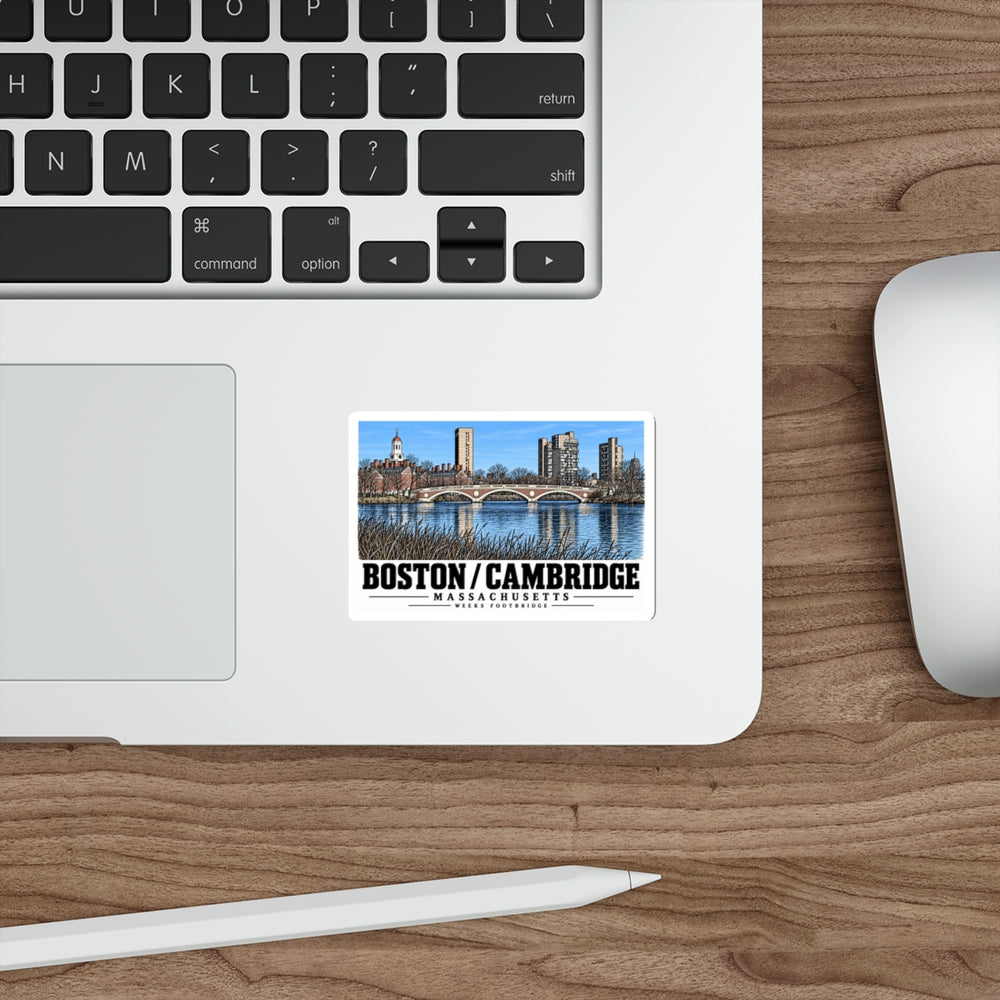 Sticker showing Weeks Footbridge stone arches and riverside towers artwork on a laptop beside its keyboard