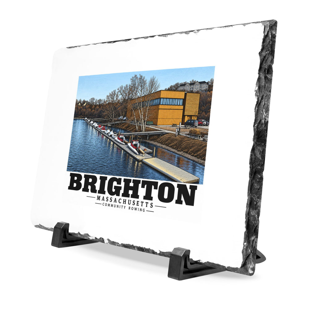Angled rough-edged slate display on black stands showing Community Rowing building, dock and boats artwork
