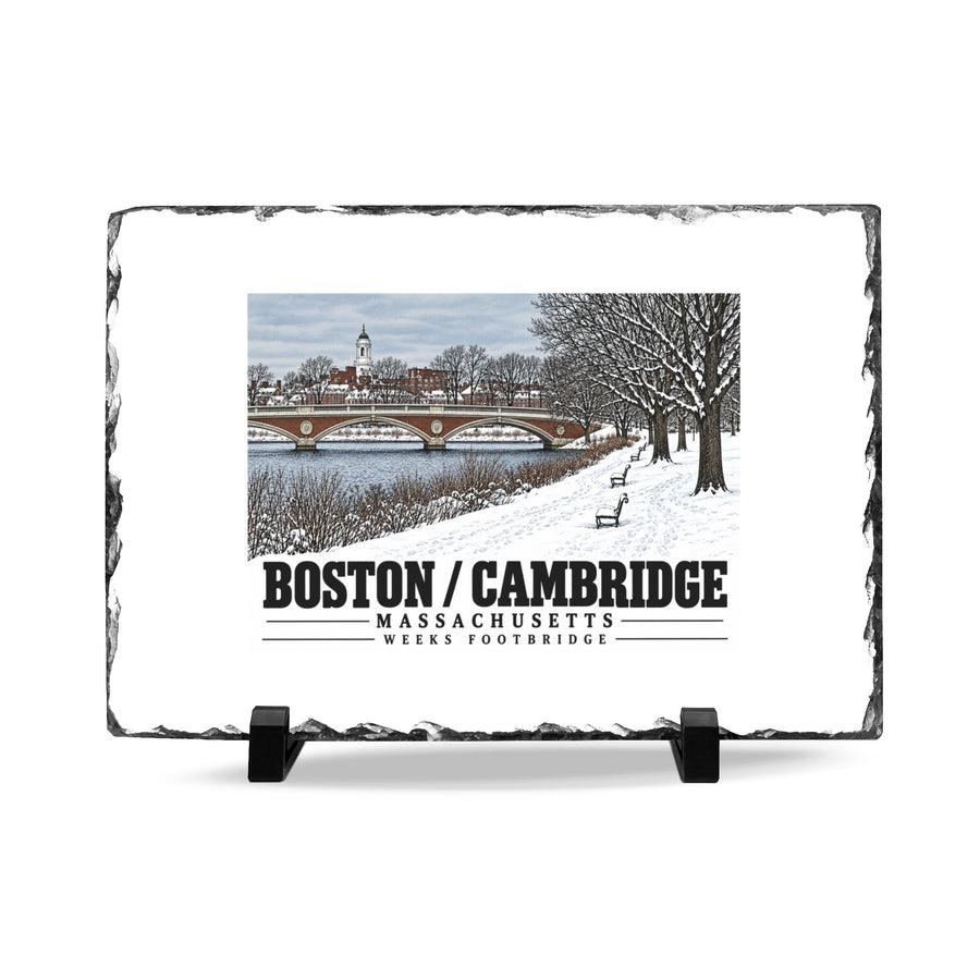 Rough-edged slate display on two black stands with Weeks Footbridge winter riverbank view with snow and benches artwork and Boston/Cambridge lettering