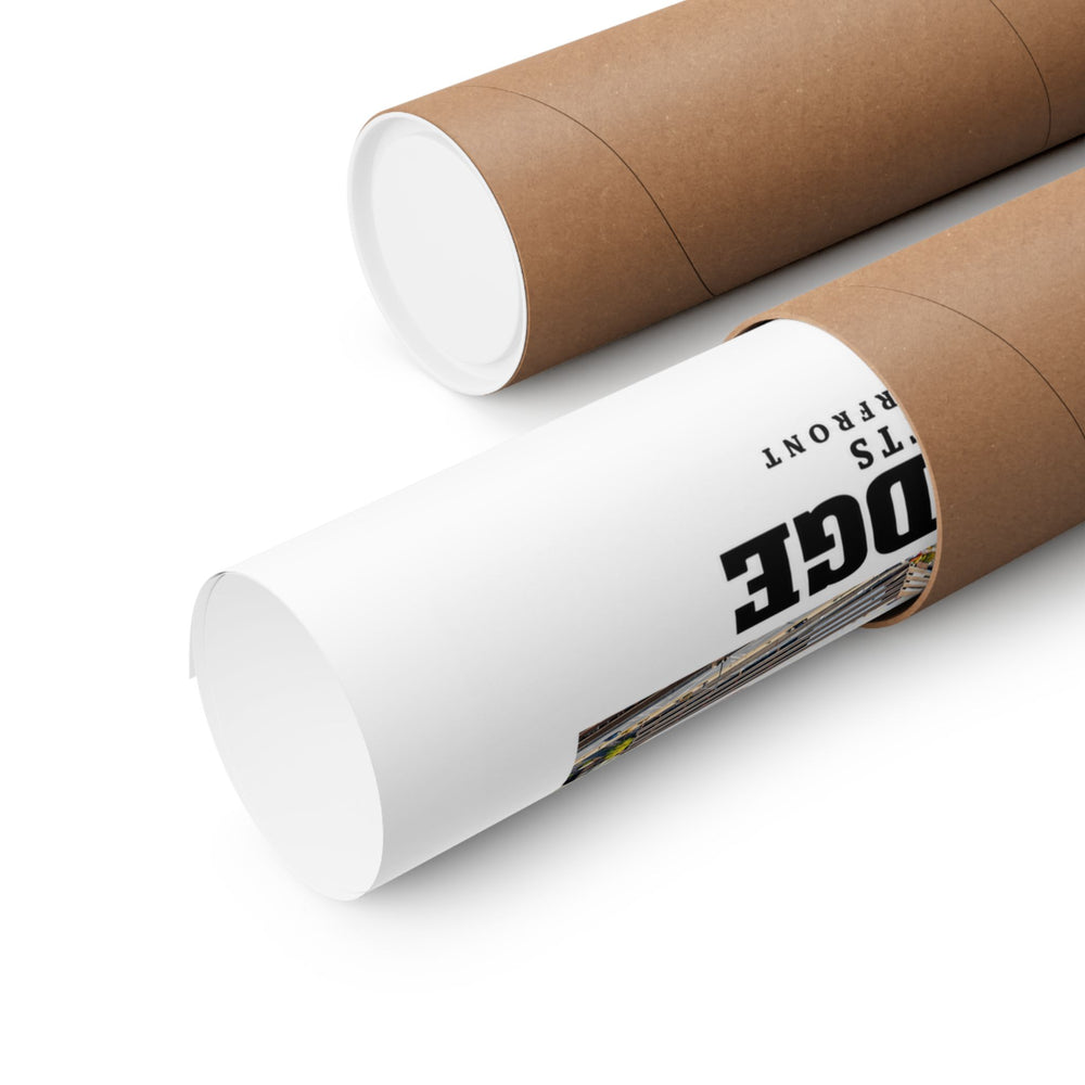 Partly rolled poster extending from a cardboard tube with partial Cambridge lettering and a narrow strip of the printed scene visible