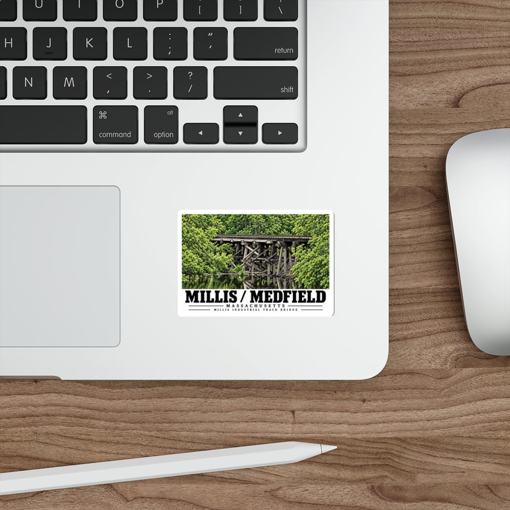 Sticker showing Millis Industrial Track wooden railway trestle and green foliage artwork on a laptop beside its keyboard