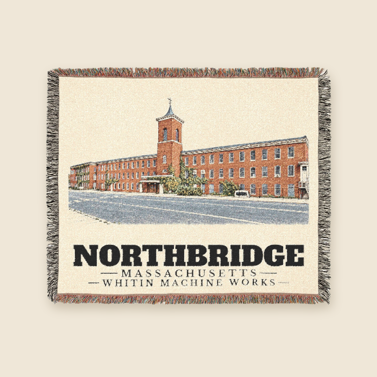 Whitin Machine Works — Northbridge, Massachusetts Woven Blanket woven blanket shown flat with fringe on a cream background